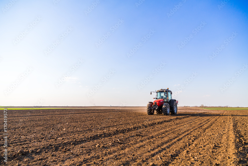 Obraz premium Farmer fertilizing arable land with nitrogen, phosphorus, potassium fertilizer
