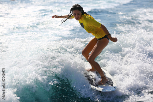 Photography Young girl surfing on the waves.