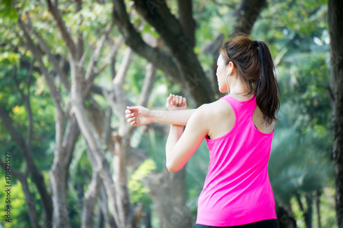 Asian sport woman stretching in park after running