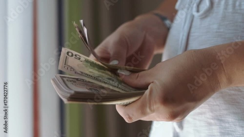 Close-up side view of hands of female counting cash money.