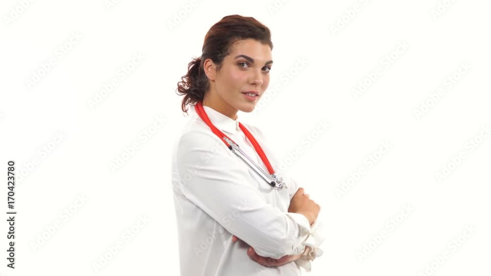 Young female doctor waving her hand, smiling friendly, crossing arms and looking at camera. Portrait of young medical professional with stethoscope and lab coat isolated on white background Young female doctor waving her hand, smiling friendly, crossing arms and looking at camera. Portrait of young medical professional with stethoscope and lab coat isolated on white background