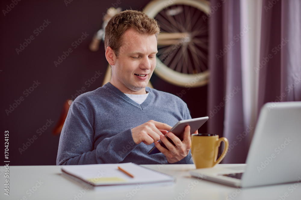 Businessman sitting and using tablet device at home office Businessman sitting and using tablet device at home office