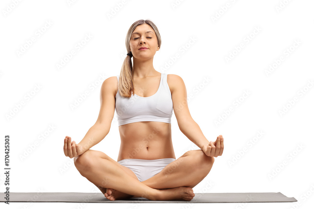 Young woman meditating on an exercise mat Young woman meditating on an exercise mat