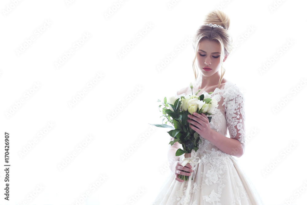 Young beautiful bride. Wedding hairstyle, blond hair, wedding dress, makeup and bride's bouquet.