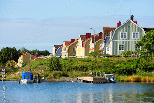 View of Salto in Karlskrona, Sweden, as seen from the north. Wooden houses along a city street and boats in the bay below.