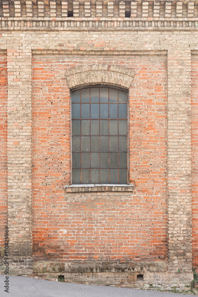 Old brick house with window protected with gratings 