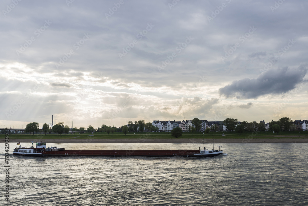 Obraz premium Merchant ship sailing on the Rhine River at dusk in Germany