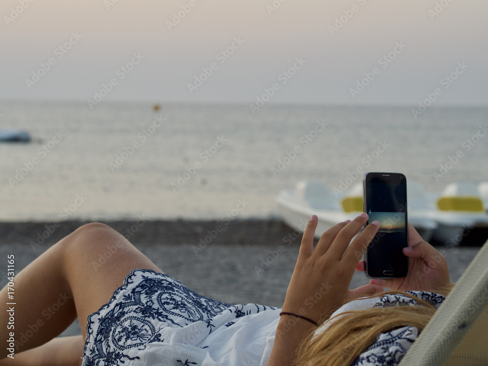 Junge Frau macht ein Foto am Strand 