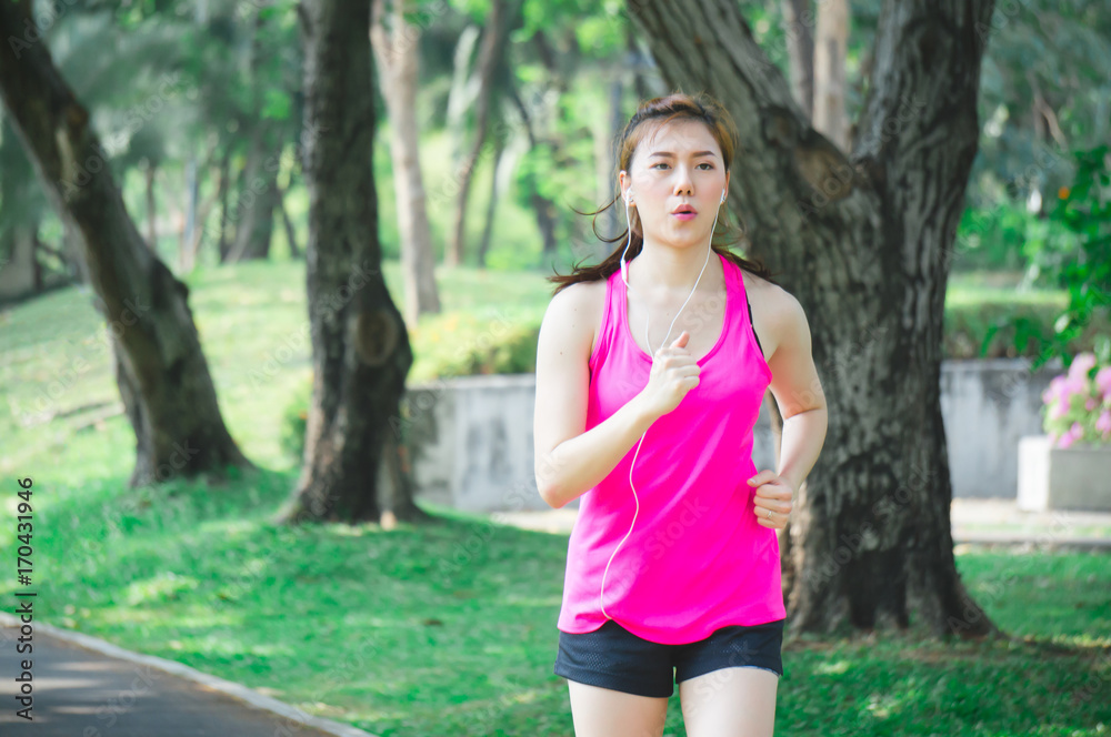 Asian sport woman running / jogging in park for health Asian sport woman running / jogging in park for health