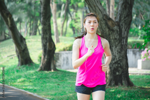 Asian sport woman running / jogging in park for health