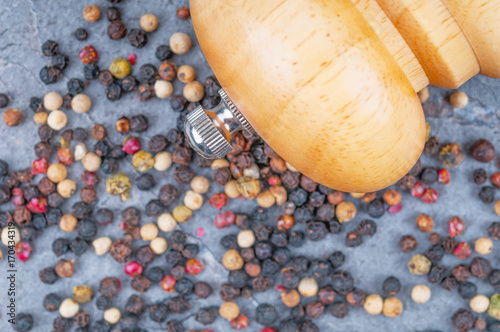 Pepper mill and dried peppercorns. Front focus photo