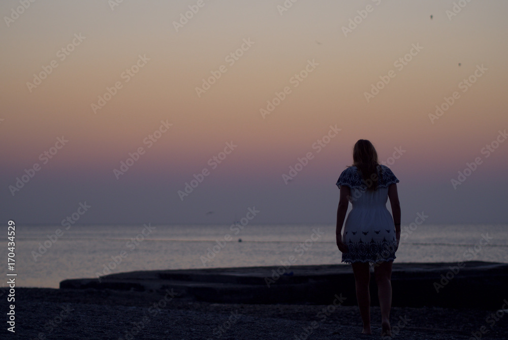 Junge Frau spaziert einsam am Strand Junge Frau spaziert einsam am Strand