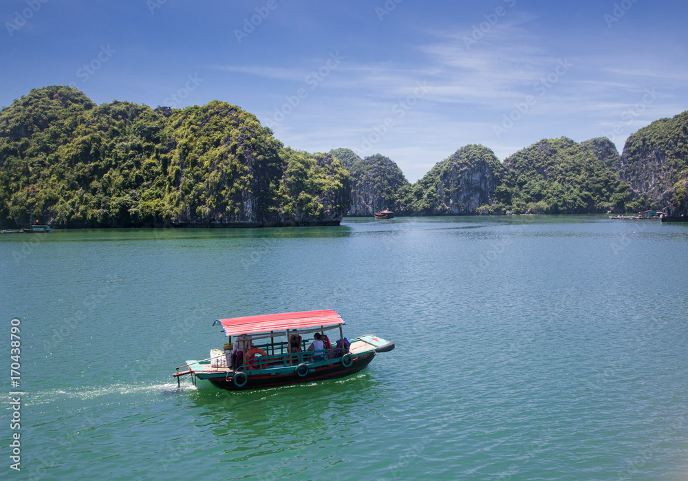 Naklejka premium cruising among beautiful limestone rocks and secluded beaches in Ha Long bay, UNESCO world heritage site, Vietnam