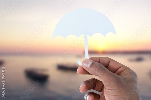 Composite image of hand holding an umbrella in paper