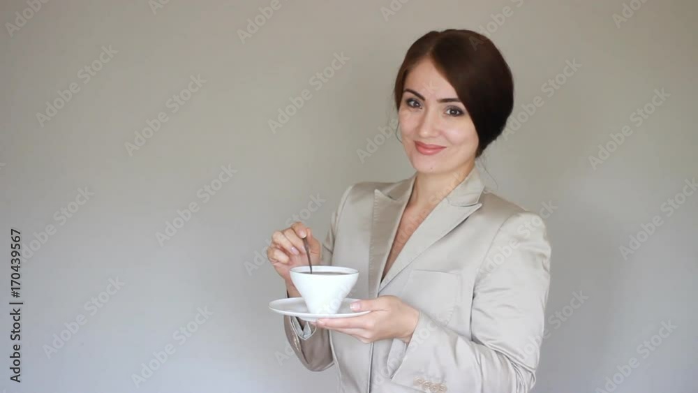 Business woman smiling, looking at camera and drinking coffee or tea. Break Business woman smiling, looking at camera and drinking coffee or tea. Break