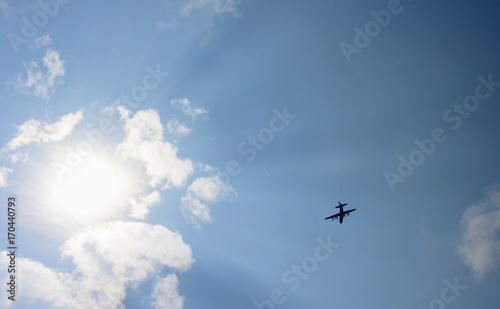 美しい青空と太陽の日差しを受け、浮かぶあがる飛行機のシルエット（祝福、栄光、未来、旅立ち、遥か彼方などのイメージ）