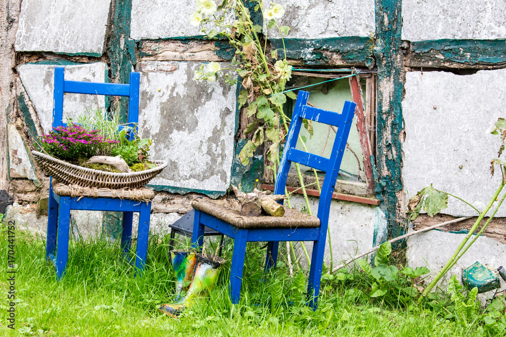 zwei blaue stühle vor einer ruine
