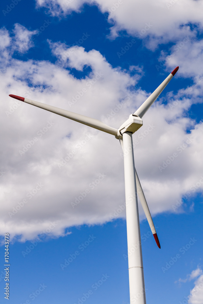 Wind turbine close-up on a background of blue sky with clouds Wind turbine close-up on a background of blue sky with clouds