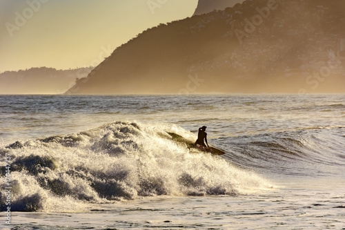 Surfer alone on the beach of Ipanema in Rio de Janeiro during the late afternoon