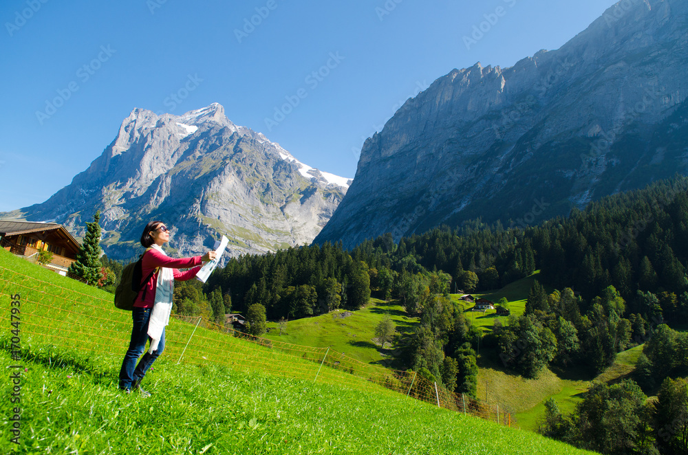 Woman holding a map and looking at mountain from grindelwald, switzerland
