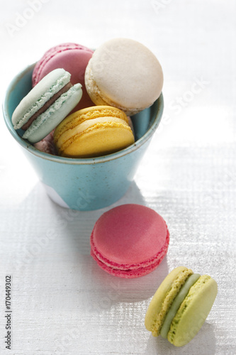 Colorful macarons on a white background. French sweets viewed from above on a white paper