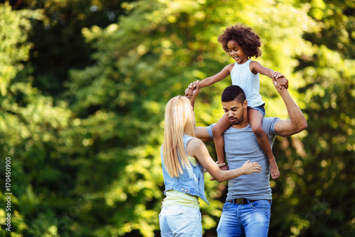 Picture of happy young couple spending time with their daughter