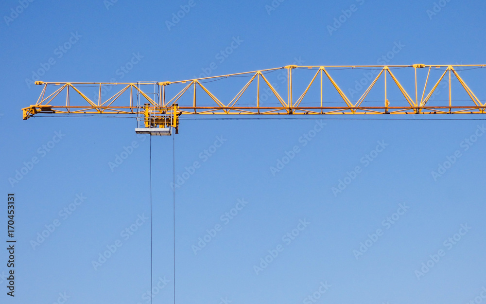 Yellow construction crane against blue sky in Lisbon, Portugal Yellow construction crane against blue sky in Lisbon, Portugal