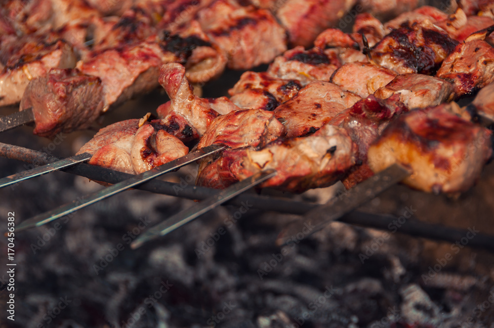 Pieces of meat fried on the grill. Appetizing pieces of roasted meat on the fire. Barbecue meat background. Top view. Pieces of meat fried on the grill. Appetizing pieces of roasted meat on the fire. Barbecue meat background. Top view.
