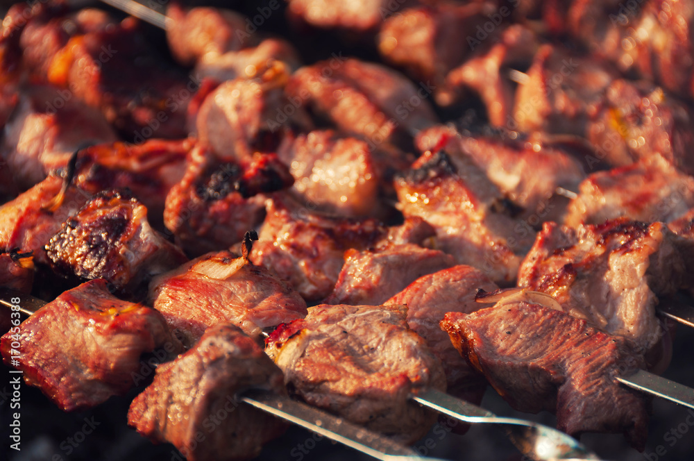 Pieces of meat fried on the grill. Appetizing pieces of roasted meat on the fire. Barbecue meat background. Top view.
