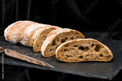 front view of fresh warm homemade bread on dark background