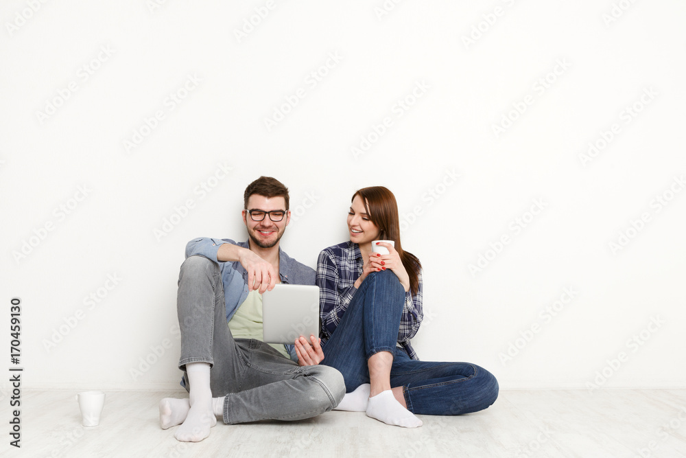 Smiling couple web-surfing on tablet, studio shot Smiling couple web-surfing on tablet, studio shot