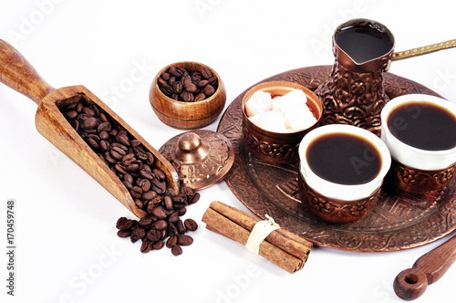 Coffee in copper coasters with accessories for coffee-drinking on a white background photo