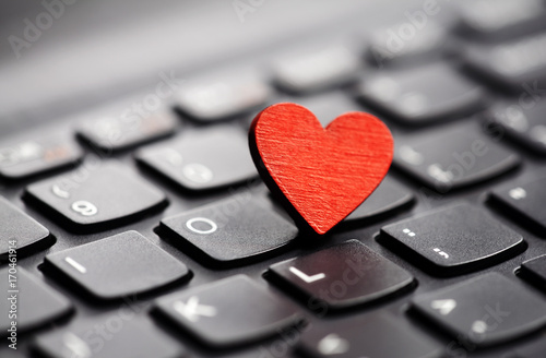 Small red heart on keyboard. Internet dating concept.