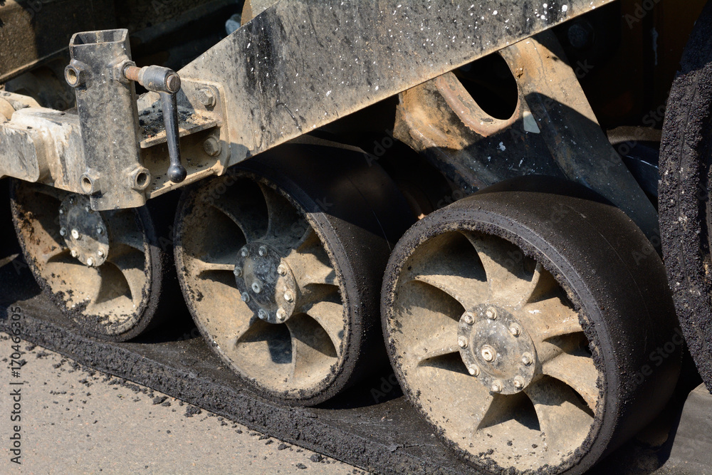 Close up of road grading machine wheels at construction site for new shopping center