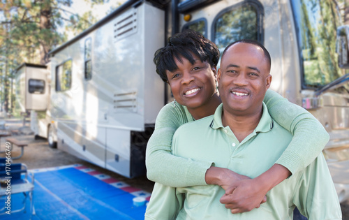 Happy African American Couple In Front of Their Beautiful RV At The Campground.
