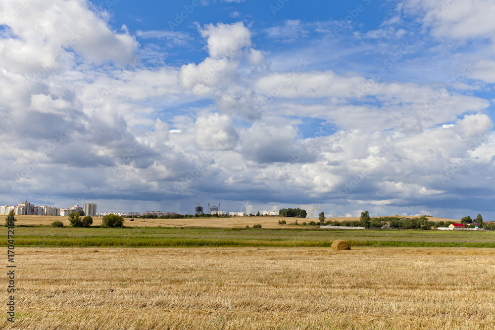 Summer sky over farm field with hay bales in Belarus