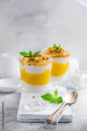 delicious mango,  passion fruit and cream cheese layered dessert on glasses