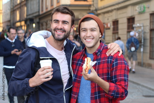 Joyful gay couple walking the city streets