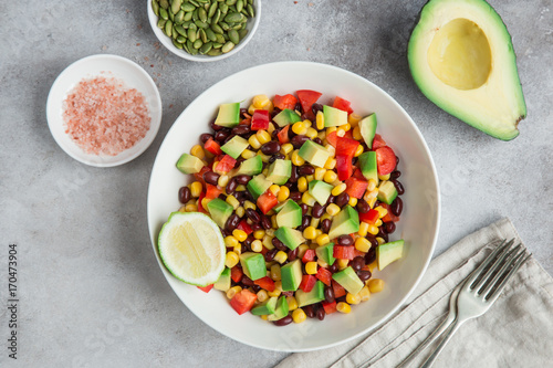 Avocado, black bean, corn and bell pepper salad in white bowl