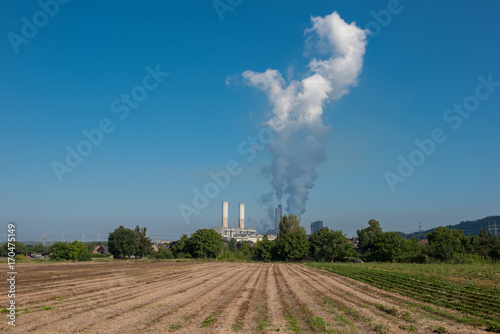 Grosses Braunkohlekraftwerk in der Natur mit aufsteigendem Wasserdampf photo