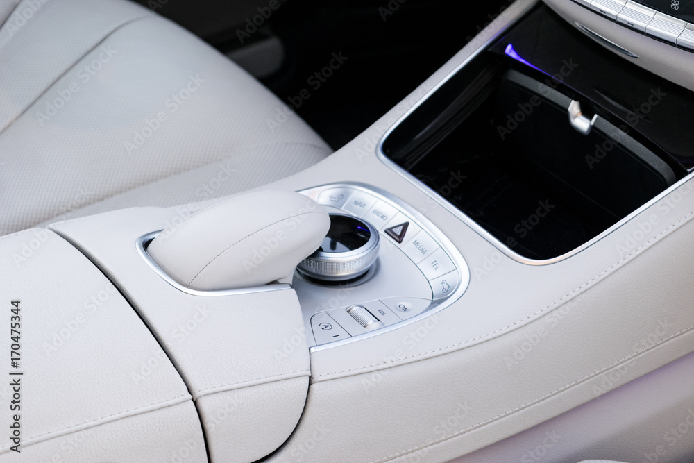 Media and navigation control buttons of a Modern car. Car interior details. White leather interior of the luxury modern car. Modern car interior