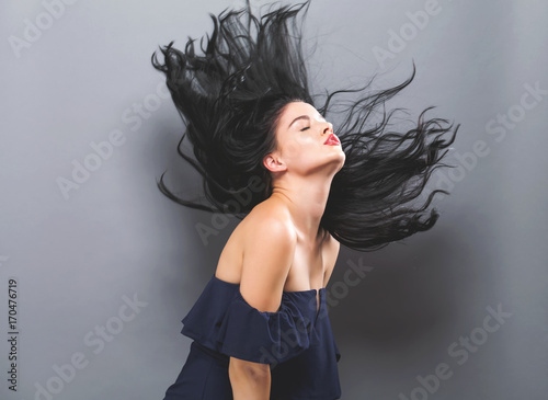 Young woman with floating hair on a solid background photo