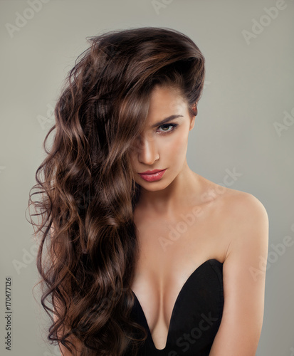 Beautiful Sexy Model with Long Curly Hair, Makeup and Black Bra. Brunette Woman with Perfect Hairstyle and Makeup