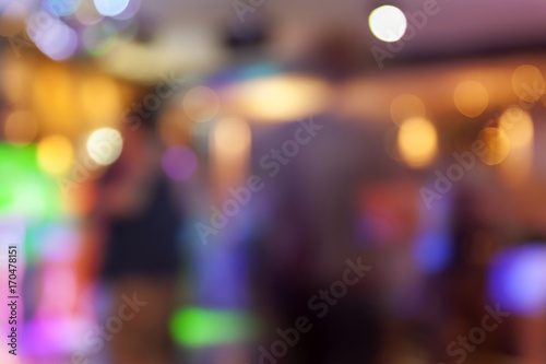 Defocused scene in the night club with bokeh lights and people silhouettes