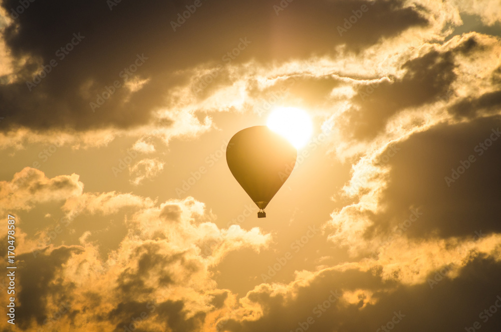 Fototapeta premium The balloon flies against the background of the sun