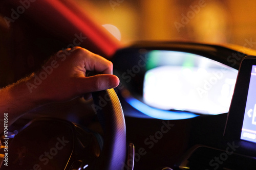 The driver's hand on the steering wheel in the car's interior