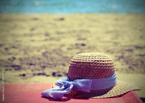 straw hat on the beach near the ocean in summer