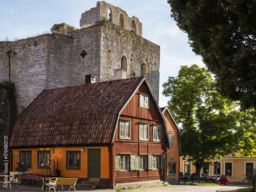 Holzhaus vor Kirchenruine