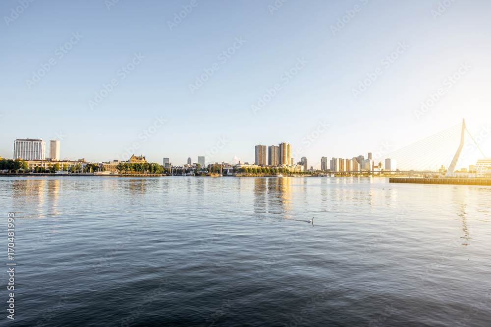 Fototapeta premium Landscape view on the beautiful riverside with skyscrapers and bridge during the morning in Rotterdam city