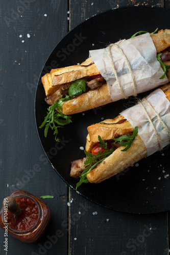 Delicious sandwich with meat with arugula and tomatoes